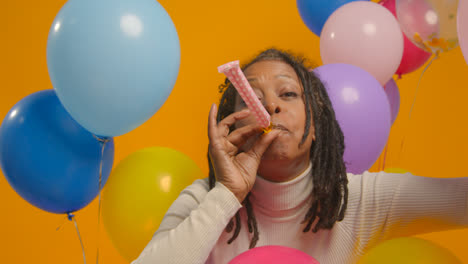 Studioporträt-Einer-Frau-Mit-Geburtstagsstirnband,-Die-Mit-Luftballons-Und-Partygebläse-Feiert-2